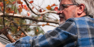 Vinson Home Inspections (1) older man working on a roof, holding a hammer in his right hand