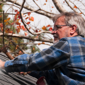 Vinson Home Inspections (1) older man working on a roof, holding a hammer in his right hand