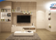 Modern living room with built-in shelving, flat-screen TV, and minimalistic decor.