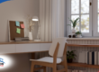 Peaceful study space with a wooden desk, lamp, and books by a window.