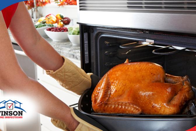 Vinson Home Inspections Person removing a golden roasted turkey from the oven, with a kitchen counter full of fresh produce in the background.